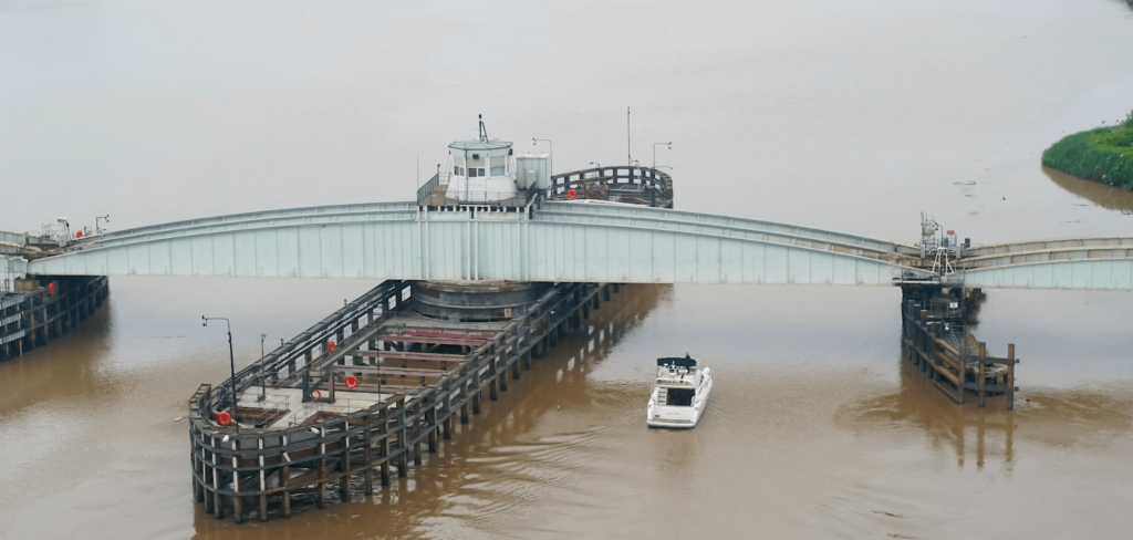 Landscape drone shot of Goole Swing Bridge with a boat travelling beneath.