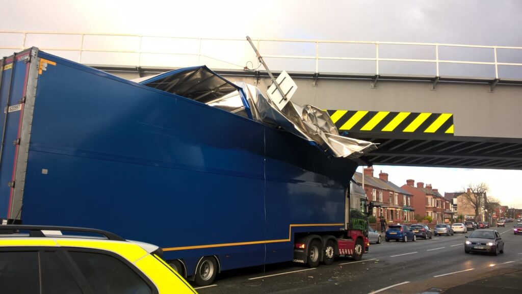 A lorry that's hit a rail bridge.