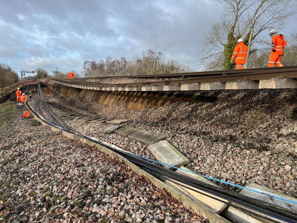 The landslip near Hook station in Hampshire. The embankment has slipped away from beneath the track bed, leaving some of the track unsupported by any ground.