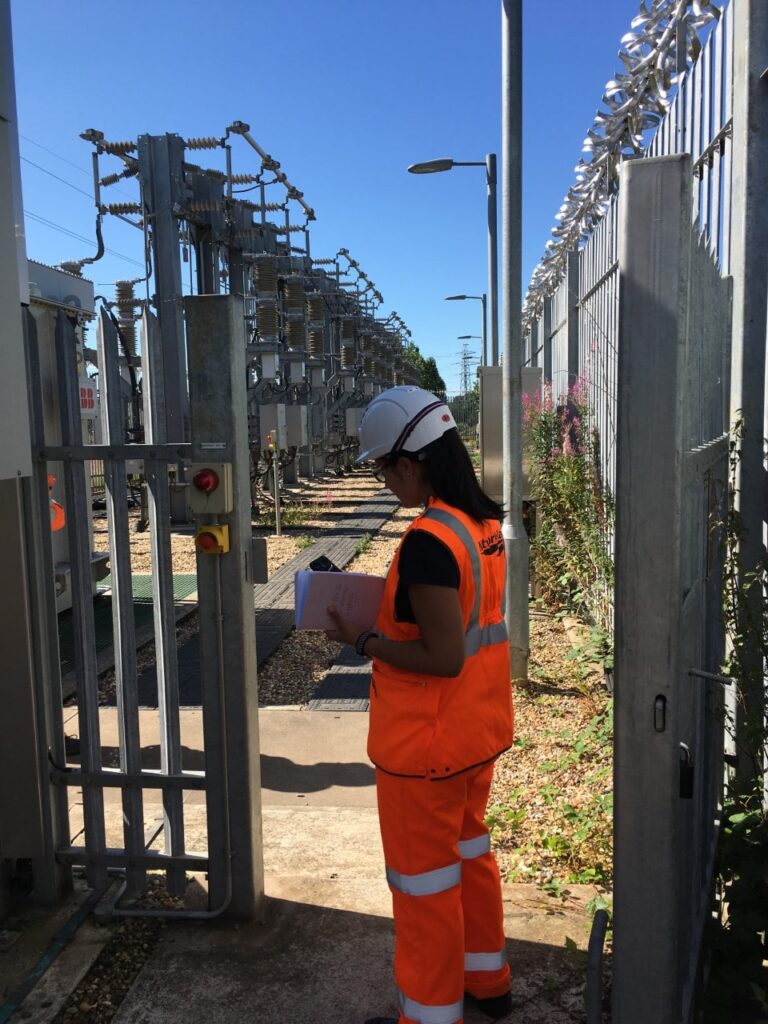 Senior engineer Nilda Sanchez in PPE during a site inspection of 25kV outdoor switchgear.