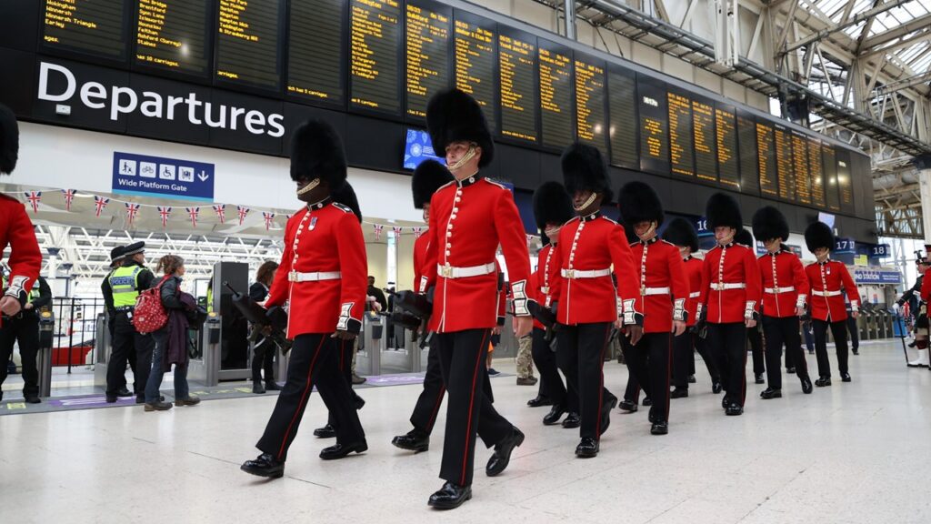 Military personnel marching through London Waterloo station on the day of the coronation.
