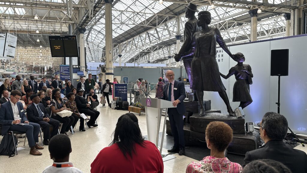 Andrew Haines, chief executive of Network Rail, speaks in front of the Windrush statue at London Waterloo station as part of a special event marking the 75th anniversary of the Empire Windrush.