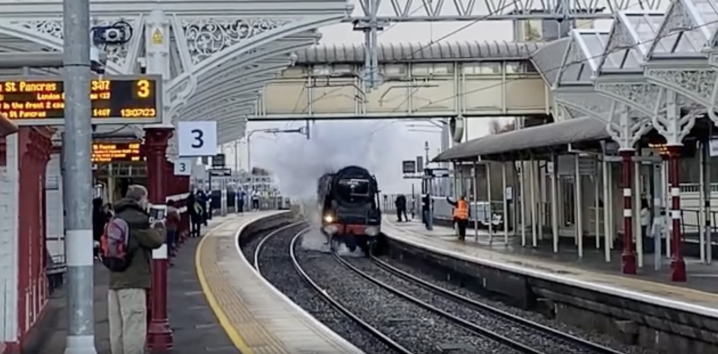 The Duchess of Sutherland steam train passing through Kettering station.