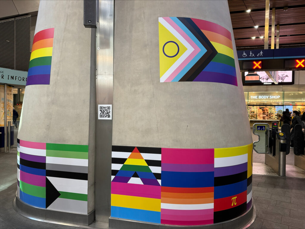 The Pride pillar at London Bridge station - a concrete pillar decorated with different Pride flags.