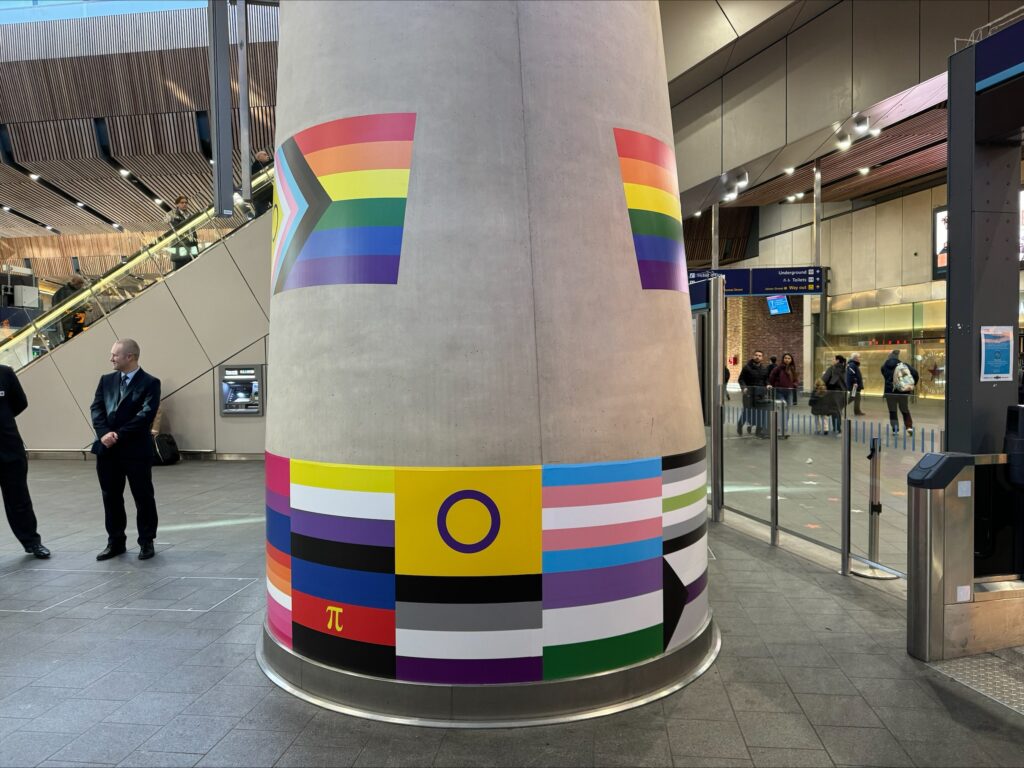 The Pride pillar at London Bridge station - a concrete pillar decorated with different Pride flags.
