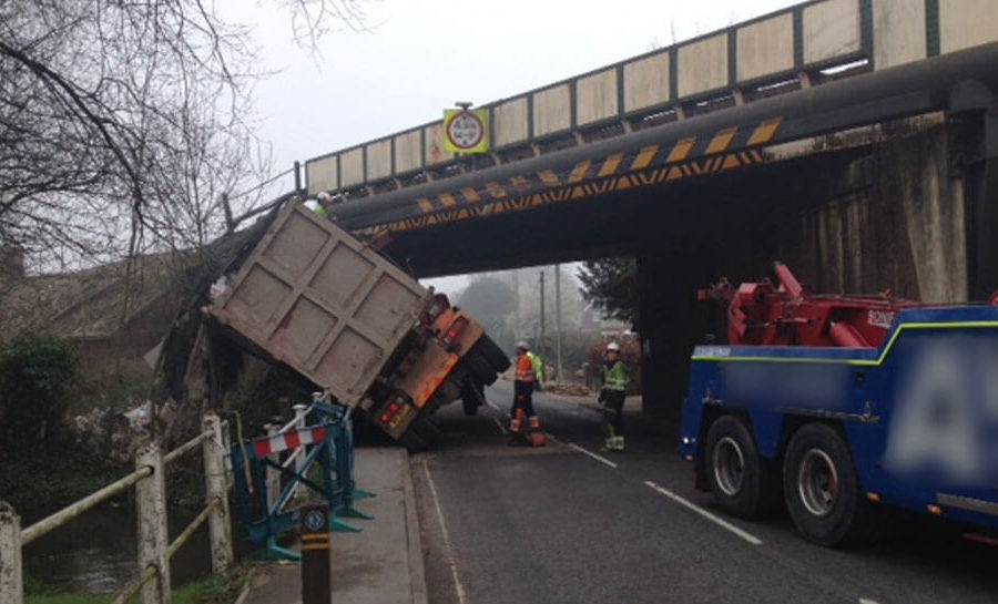 A lorry on it's side after hitting a bridge