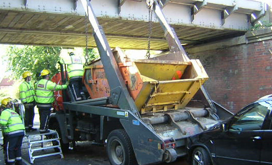 a Skip lorry after crashing into a low bridge