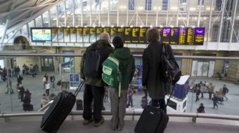 Passengers looking at departure board at King's Cross