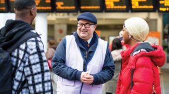 Member-of-station-staff-with-passengers